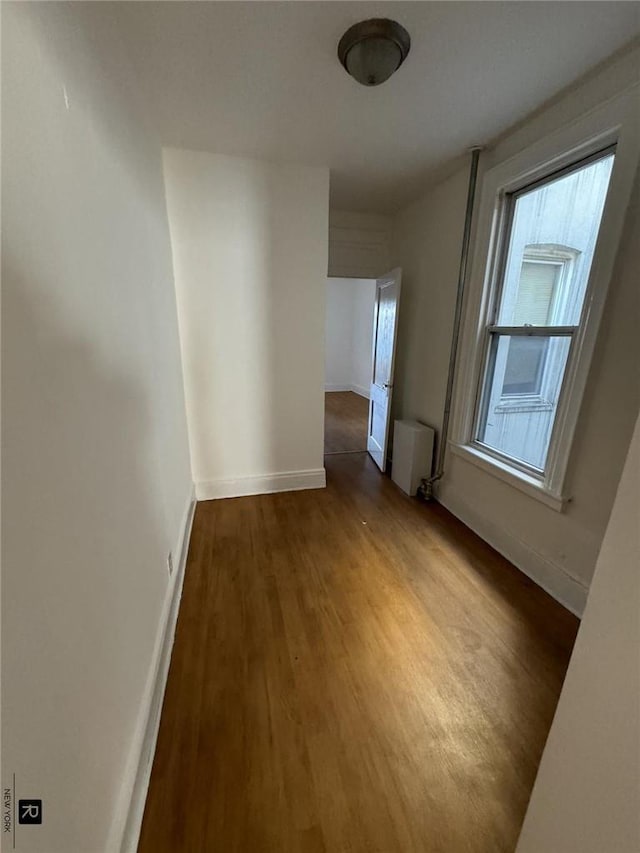 interior space with wood-type flooring and radiator heating unit