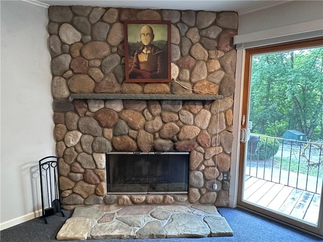 interior details with a stone fireplace, crown molding, and carpet