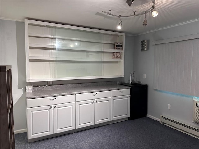 bar featuring track lighting, ornamental molding, a baseboard heating unit, dark colored carpet, and white cabinetry