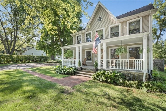 view of front of property with a porch and a front lawn