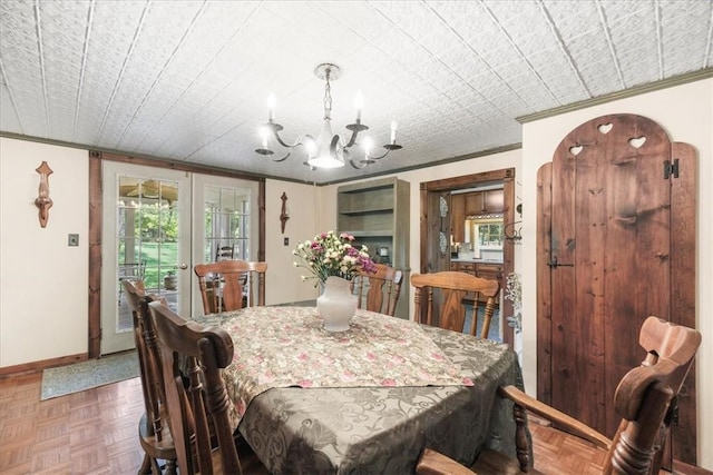 dining area featuring crown molding, french doors, parquet floors, and an inviting chandelier