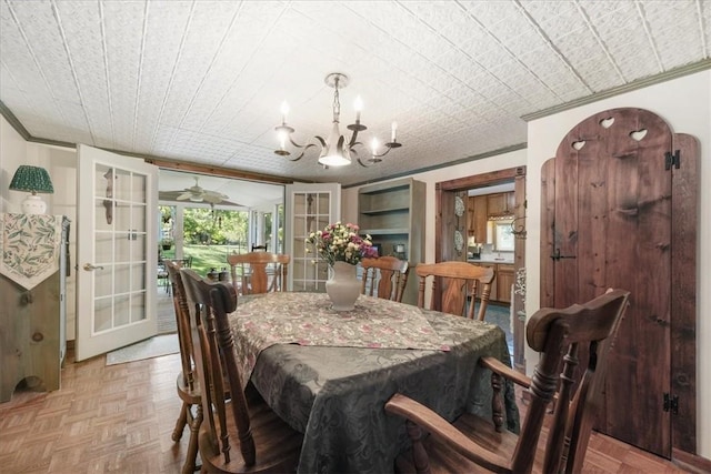 dining space featuring french doors, light parquet floors, a chandelier, and ornamental molding