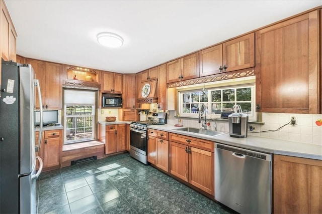 kitchen featuring decorative backsplash, stainless steel appliances, a wealth of natural light, and sink