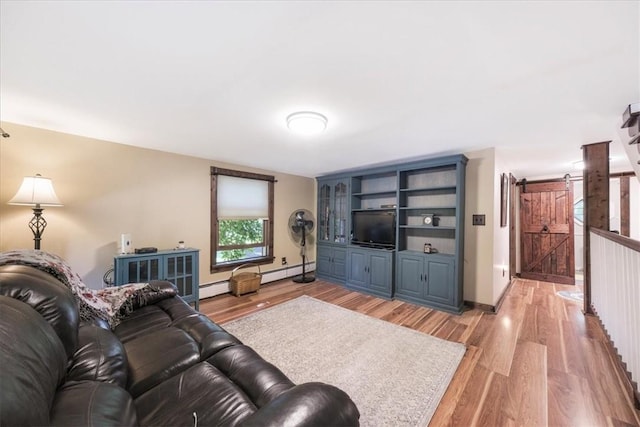 living room with a barn door, a baseboard radiator, and light wood-type flooring