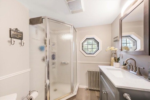 bathroom featuring an enclosed shower, vanity, hardwood / wood-style flooring, and radiator