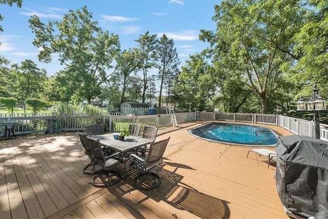 view of swimming pool featuring a deck and grilling area