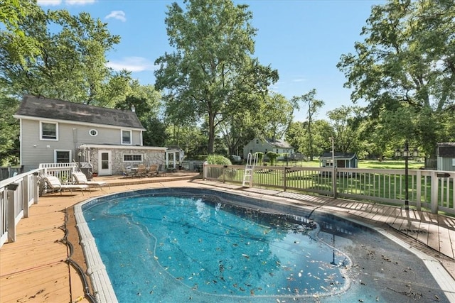 view of pool featuring a deck and an outdoor structure