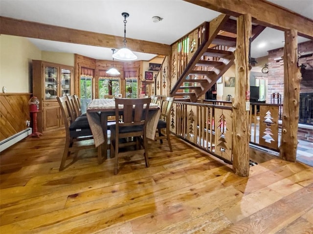 dining space with wooden walls and hardwood / wood-style floors