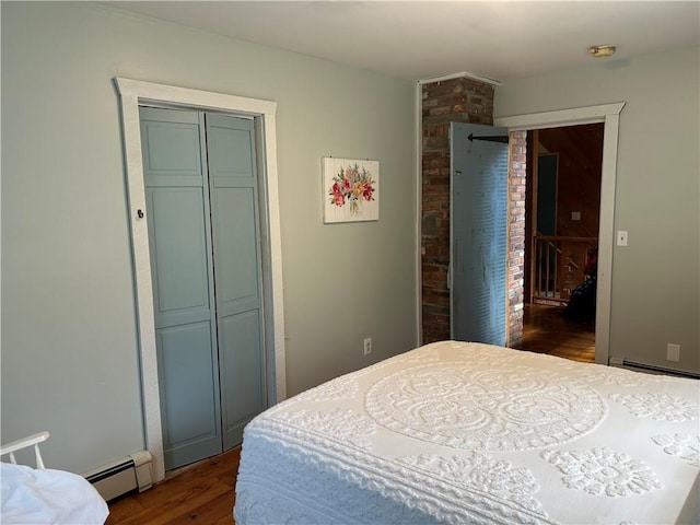 bedroom featuring dark hardwood / wood-style floors, baseboard heating, and a closet