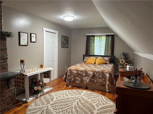 bedroom featuring lofted ceiling, wood-type flooring, and a closet