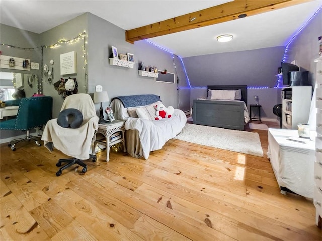 bedroom with beamed ceiling and hardwood / wood-style floors