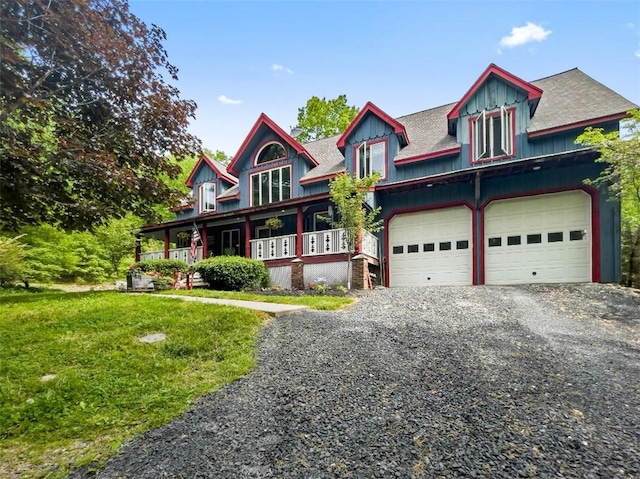 view of front of property with a front lawn, covered porch, and a garage