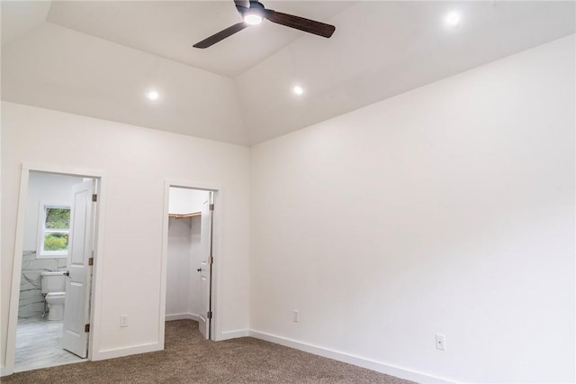 unfurnished bedroom with connected bathroom, a spacious closet, ceiling fan, vaulted ceiling, and a closet