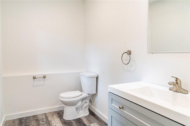 bathroom with hardwood / wood-style floors, vanity, and toilet