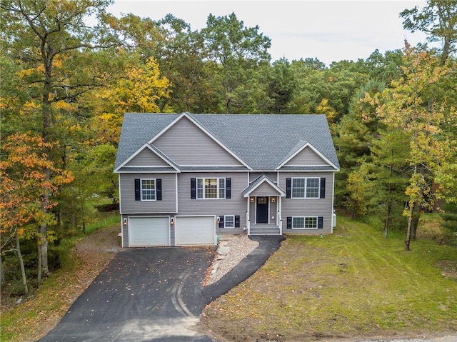 raised ranch featuring a front yard and a garage