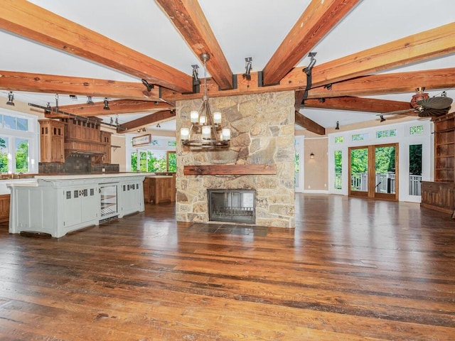 33 Truesdale Lake Dr, South Salem, NY 10590 - unfurnished living room with a stone fireplace, dark wood-style floors, beamed ceiling, a chandelier, and french doors