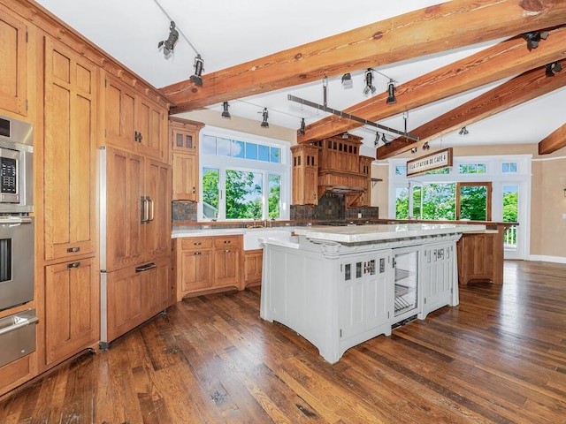 33 Truesdale Lake Dr, South Salem, NY 10590 - kitchen featuring a warming drawer, dark wood-type flooring, light countertops, track lighting, and beamed ceiling