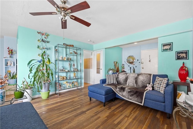 living room featuring ceiling fan and dark wood-type flooring