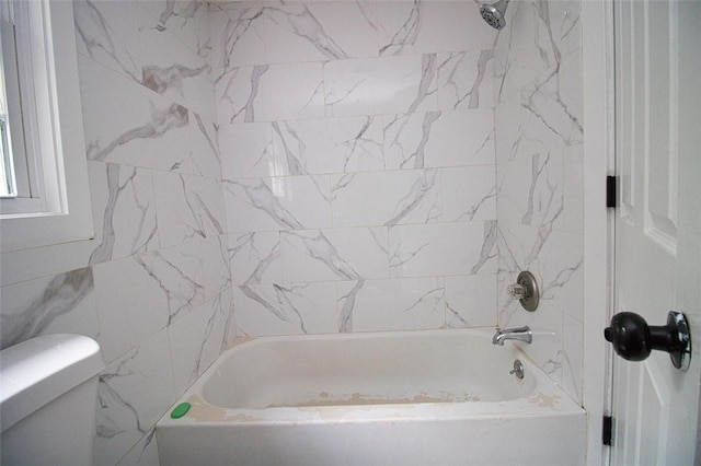 bathroom featuring  shower combination, toilet, and tile walls