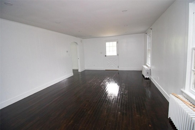 empty room featuring dark hardwood / wood-style flooring and radiator