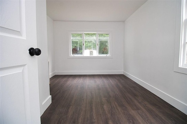 unfurnished room with dark wood-type flooring