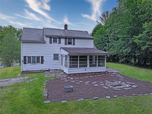 back of house featuring a sunroom and a yard