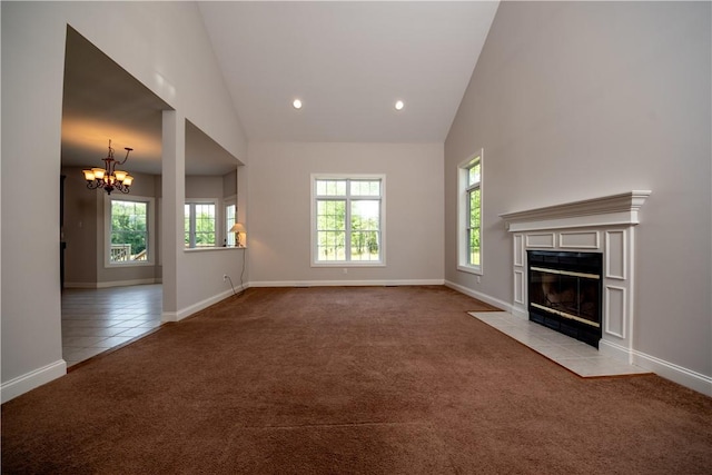 unfurnished living room featuring light carpet, high vaulted ceiling, and an inviting chandelier