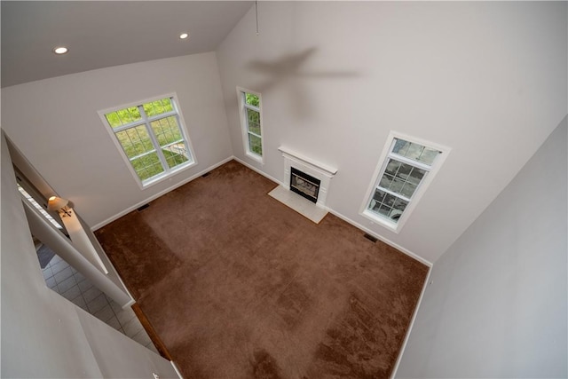 carpeted living room with high vaulted ceiling