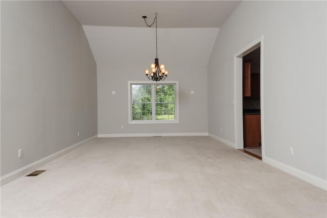 carpeted empty room with an inviting chandelier and vaulted ceiling