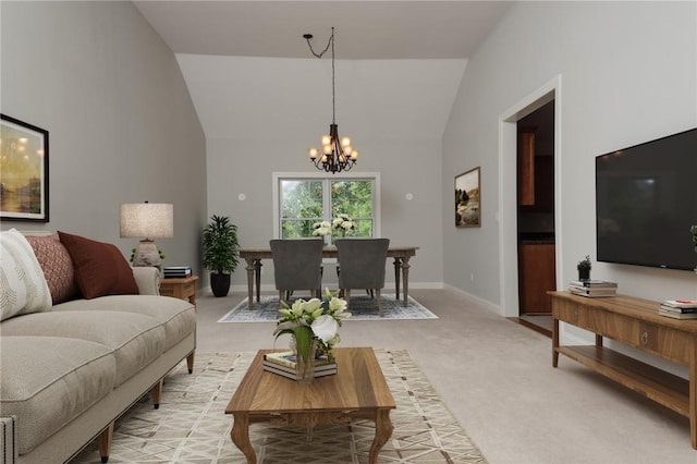 carpeted living room featuring high vaulted ceiling and an inviting chandelier