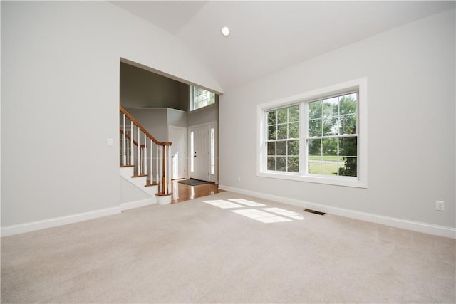 unfurnished living room with carpet and vaulted ceiling