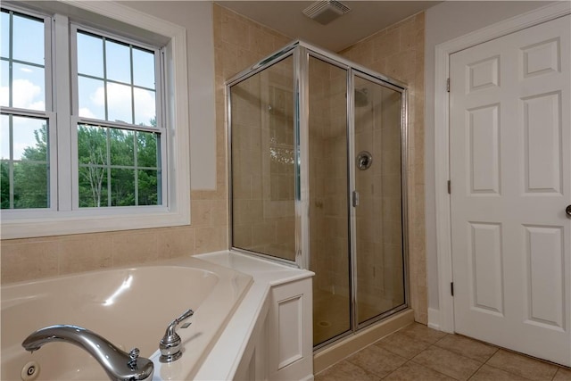 bathroom featuring tile patterned floors and separate shower and tub