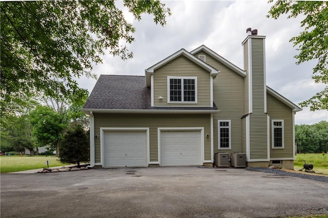 view of front facade featuring central AC and a garage