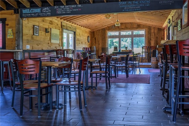 dining space featuring hardwood / wood-style flooring, wood walls, lofted ceiling, and wood ceiling