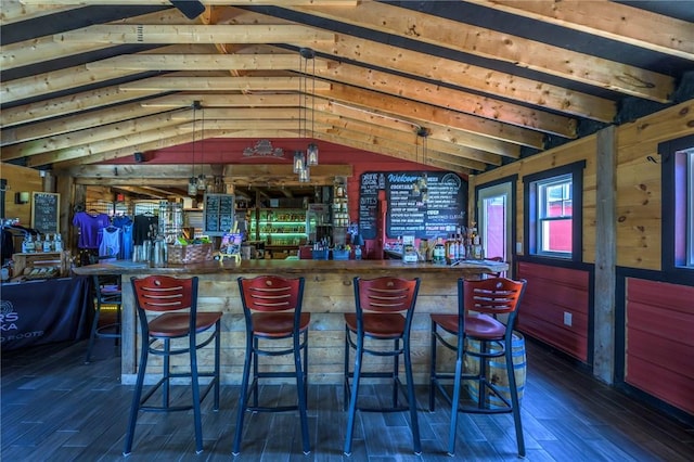 bar with pendant lighting, lofted ceiling, and dark wood-type flooring