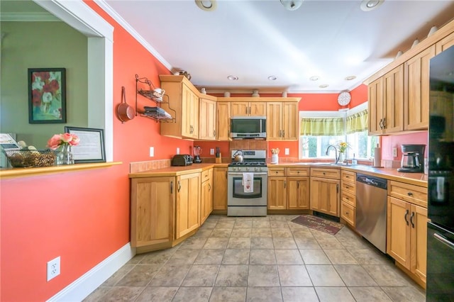 kitchen featuring sink, crown molding, light tile patterned floors, and stainless steel appliances