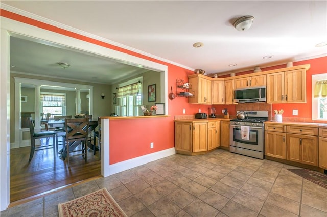 kitchen featuring light hardwood / wood-style floors, ornamental molding, and stainless steel appliances