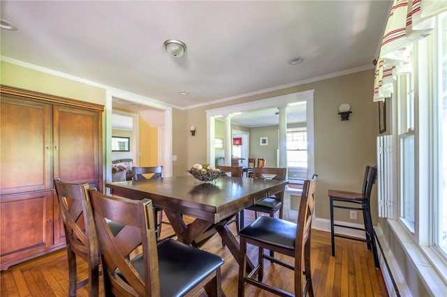 dining room featuring ornamental molding, a baseboard radiator, ornate columns, and dark wood-type flooring