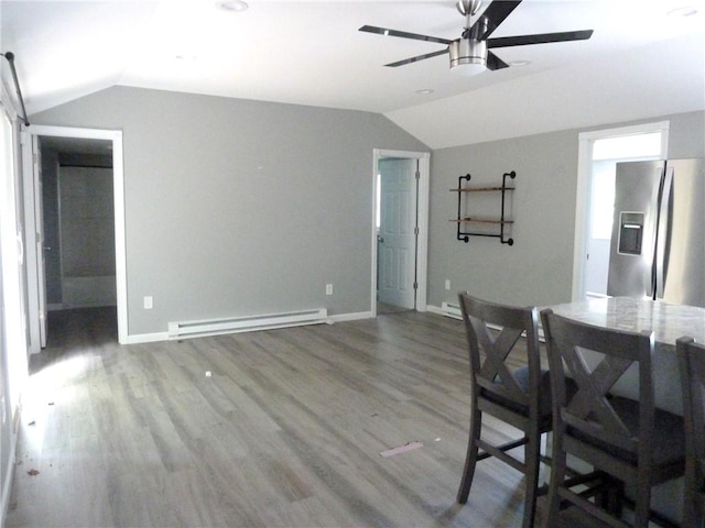 unfurnished dining area featuring vaulted ceiling, baseboard heating, and dark wood-type flooring