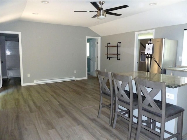 dining area featuring ceiling fan, dark wood-type flooring, lofted ceiling, and a baseboard heating unit