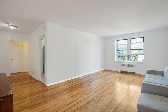 unfurnished living room featuring light hardwood / wood-style floors and radiator heating unit