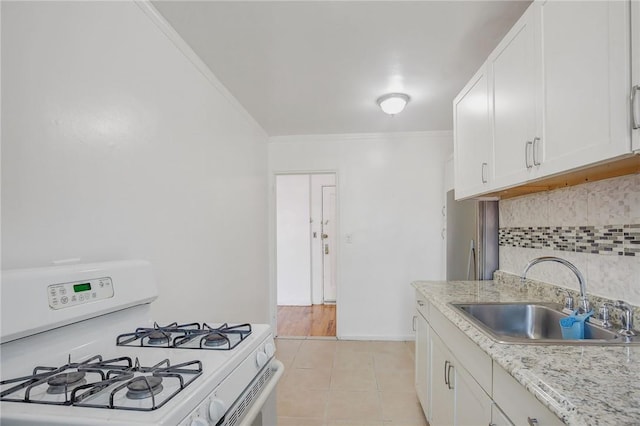 kitchen featuring white cabinets, white gas stove, decorative backsplash, and sink