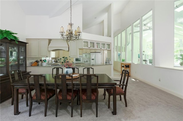 dining area featuring light carpet, sink, high vaulted ceiling, and an inviting chandelier