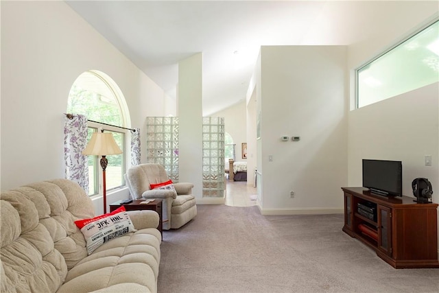 carpeted living room featuring high vaulted ceiling