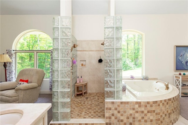 bathroom featuring tile patterned flooring, vanity, and a tile shower