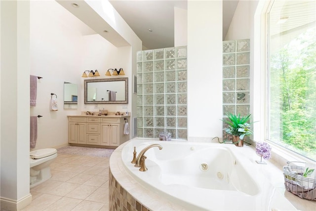 bathroom featuring tiled bath, tile patterned flooring, vanity, and toilet