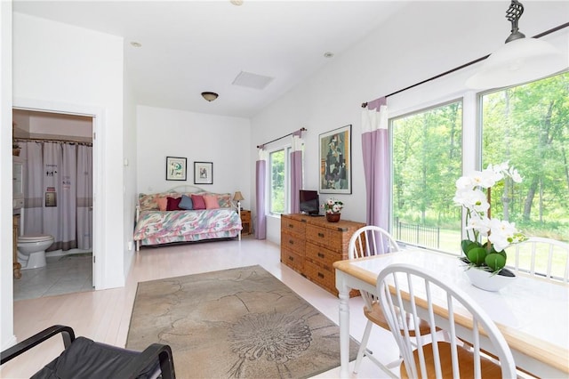 bedroom featuring connected bathroom and light hardwood / wood-style flooring