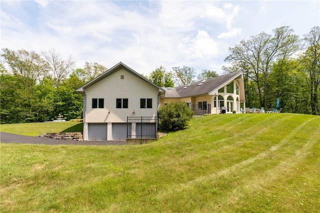 back of property with a lawn and a garage