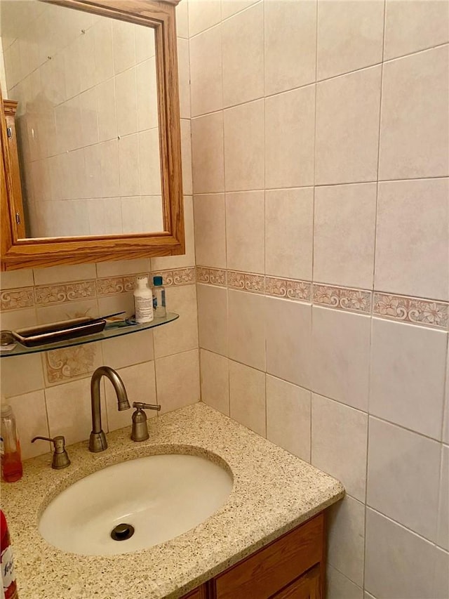 bathroom featuring tasteful backsplash, vanity, and tile walls