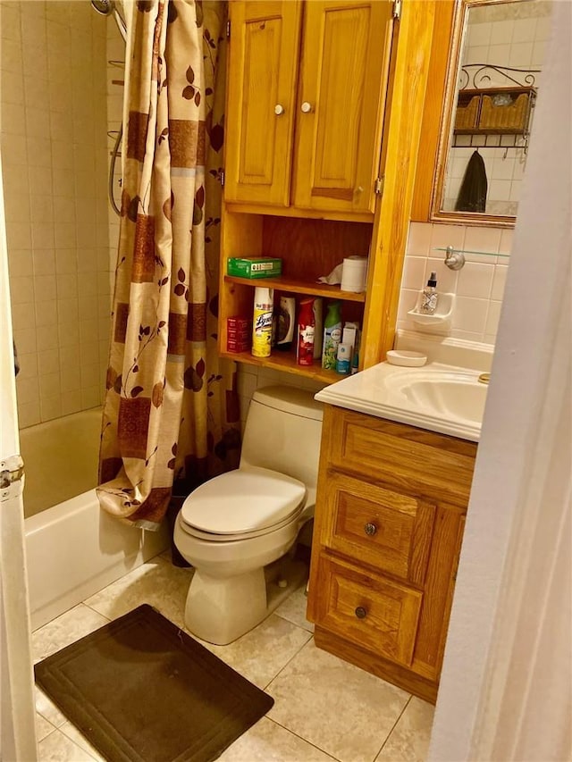 full bathroom featuring tile patterned floors, shower / bath combo with shower curtain, vanity, and toilet